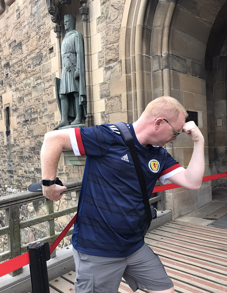 Pete does a Brucie in front of the statue of Robert The Bruce