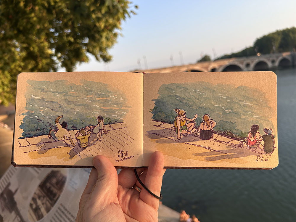 photo of my sketchbook showing sketches of people sat by the river in Toulouse